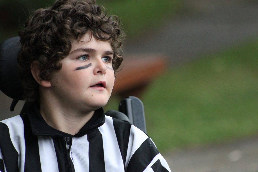 Young boy dressed as a referee in his wheelchair